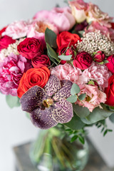 beautiful fresh cut bouquet of mixed flowers in vase on wooden table. . the work of the florist at a flower shop. Delicate Pastel tones color