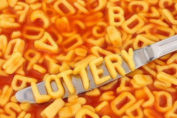 Alphabet spaghetti spelling lottery with random letters in tomato sauce background
