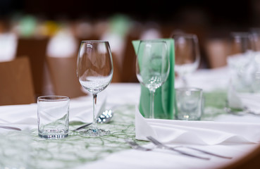 Decorated table on a gala dinner party with wine glasses and blurred out background
