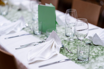 Decorated table on a gala dinner party with wine glasses and blurred out background