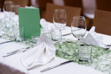 Decorated table on a gala dinner party with wine glasses and blurred out background