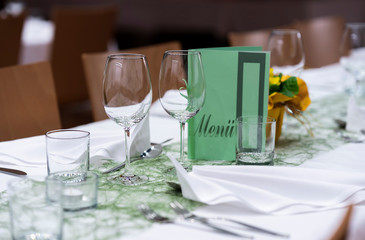 Decorated table on a gala dinner party with wine glasses and blurred out background