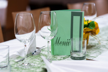 Decorated table on a gala dinner party with wine glasses and blurred out background