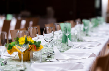 Decorated table on a gala dinner party with wine glasses and blurred out background
