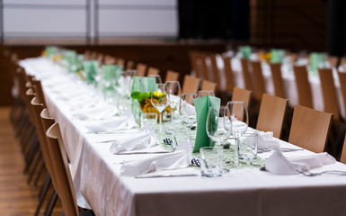 Decorated table on a gala dinner party with wine glasses and blurred out background