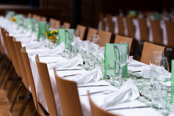 Decorated table on a gala dinner party with wine glasses and blurred out background