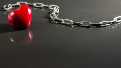 red heart and chain isolated on a shiny surface,