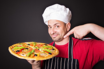 Portrait of happy attractive cook with a pizza