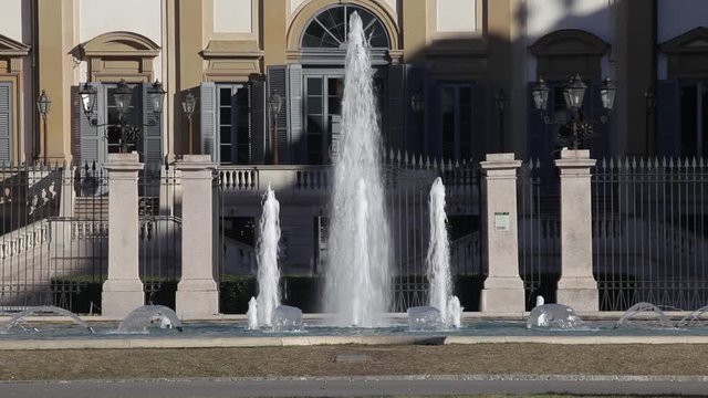 Fountain pouring water and ancient historical royal palace of villa reale monza