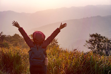 Female tourists are on the top of the gray hills in the mist at the sunrise in the autumn.