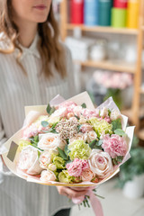 beautiful fresh cut bouquet of mixed flowers in woman hand. the work of the florist at a flower shop. Delicate Pastel tones color