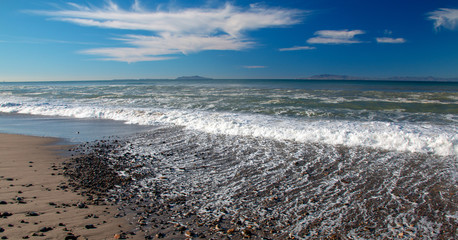 Morning seafoam washing over gravel on beach at McGrath State Park in Oxnard California United States