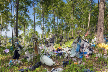 Total pollution of the environment with plastic waste. Forest with plastic non-degradable rubbish. Image of environmental pollution and terrible ecology.