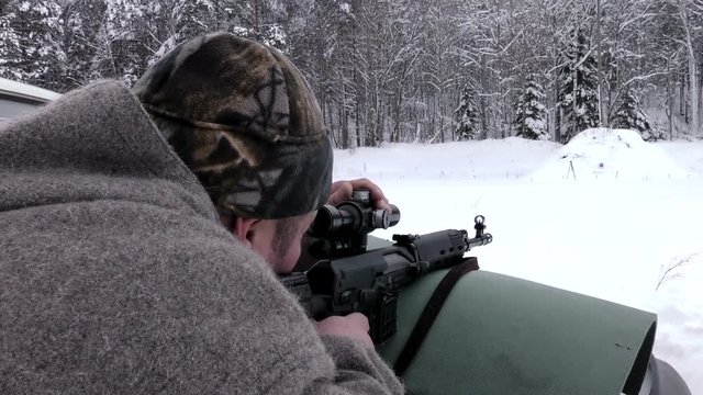 A man shoots a carbine in the winter. A firearm is lethal force.