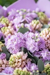 Bouquets of pink hyacinths and matthiola of lilac color in vase on wooden table. Spring flowers from Dutch gardener. Concept of a florist in a flower shop. Wallpaper.
