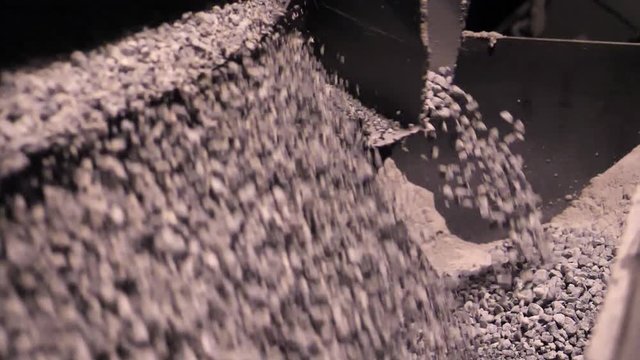 Selection and crushing of crushed rubble and stone. Close-up of separation of crushed stone on automatic machine conveyor mining enterprise