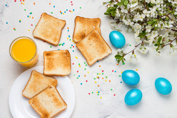 Easter Blue Eggs, Toasts and Orange Juice on the Light Background. Top View.