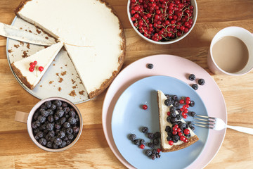 Slice of cheesecake with red currant and blackberries