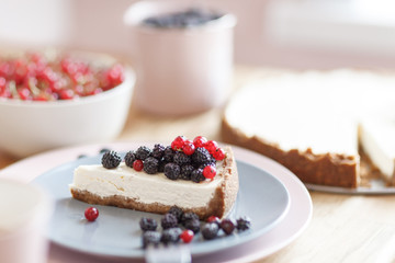 Slice of cheesecake with red currant and blackberries