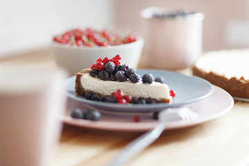 Slice of cheesecake with red currant and blackberries