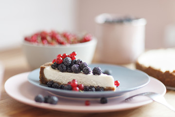 Slice of cheesecake with red currant and blackberries