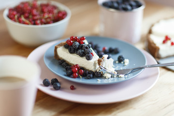 Slice of cheesecake with red currant and blackberries