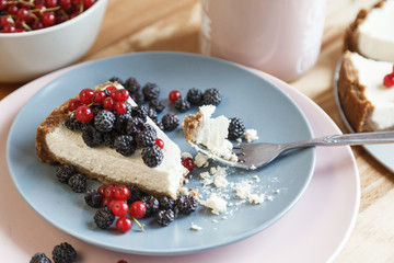 Slice of cheesecake with red currant and blackberries