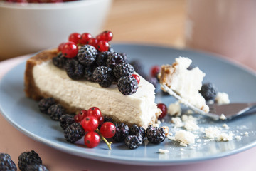 Slice of cheesecake with red currant and blackberries