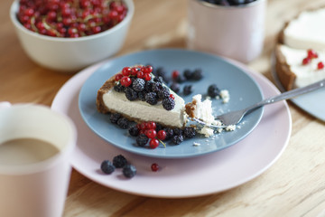 Slice of cheesecake with red currant and blackberries