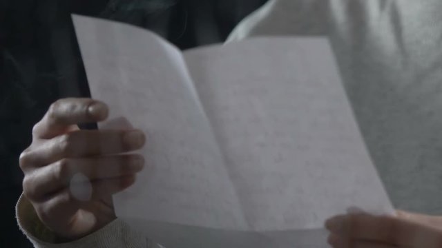 Annoyed woman from penal colony reading and crumpling private letter, aggression