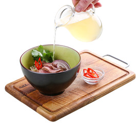 Spicy Asian soup with veal on a wooden Board. On white background.