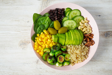 budha bowl with brussel cabbage, corn, quinoa, cucumbers,nuts, avocado and spinach