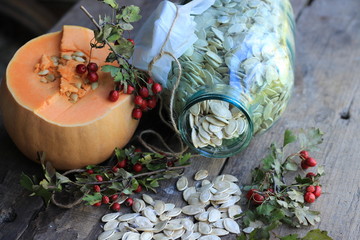 pumpkin seeds in the glass jar and a pumpkin