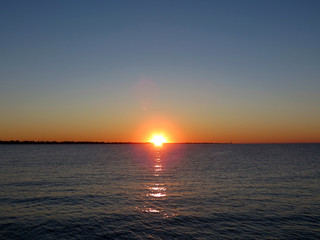 Beautiful sunset over the Adriatic sea,  berth in Rimini, Italy, Europe. The hot  sun sets in the warm water.