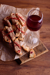 Delicious biscotti cookies with dried cherries and hazelnuts. Organic style. A glass of red wine.