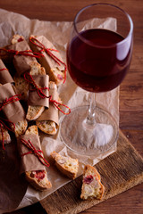 Delicious biscotti cookies with dried cherries and hazelnuts. Organic style. A glass of red wine.