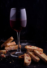 Delicious biscotti cookies with dried cherries and hazelnuts. Organic style. A glass of red wine.