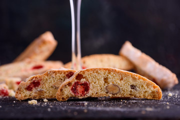 Delicious biscotti cookies with dried cherries and hazelnuts. Organic style. A glass of red wine.