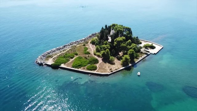 Aerial drone bird's eye view video of iconic small island of Pontikonisi or Mouse island in area of Kanoni, Corfu island, Ionian, Greece