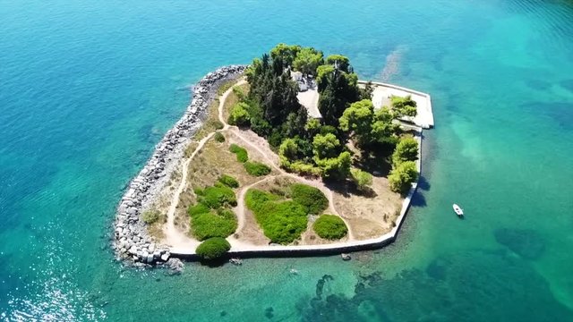 Aerial drone bird's eye view video of iconic small island of Pontikonisi or Mouse island in area of Kanoni, Corfu island, Ionian, Greece