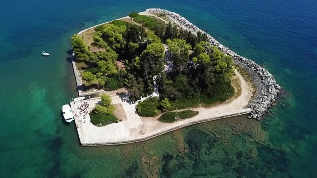 Aerial drone bird's eye view video of iconic small island of Pontikonisi or Mouse island in area of Kanoni, Corfu island, Ionian, Greece
