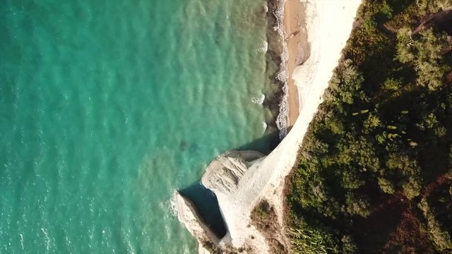 Aerial drone video of iconic white rock steep cliff volcanic bay of Cape Drastis and Peroulades area with tropical deep turquoise clear sea, Corfu island, Ionian, Greece