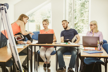 Students and teacher tutor in classroom