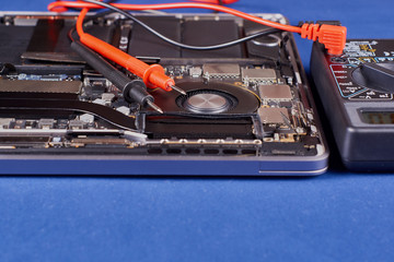 Diagnostics using a tester laptop with a fan in an aluminum case on a blue velvet background. Close-up
