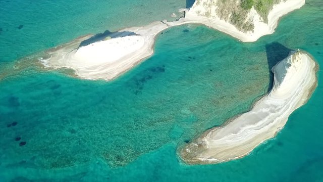 Aerial drone video of iconic white rock steep cliff volcanic bay of Cape Drastis and Peroulades area with tropical deep turquoise clear sea, Corfu island, Ionian, Greece