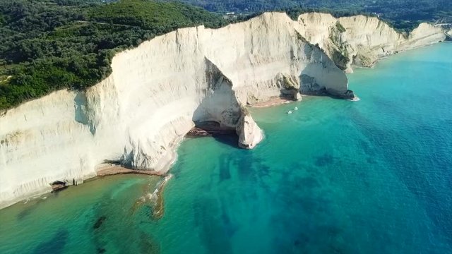 Aerial drone video of iconic white rock steep cliff volcanic bay of Cape Drastis and Peroulades area with tropical deep turquoise clear sea, Corfu island, Ionian, Greece
