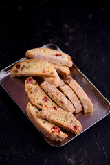 Delicious biscotti cookies with dried cherries and hazelnuts with black tea and white cup. Organic...