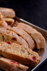 Delicious biscotti cookies with dried cherries and hazelnuts with black tea and white cup. Organic style. White cup of tea.