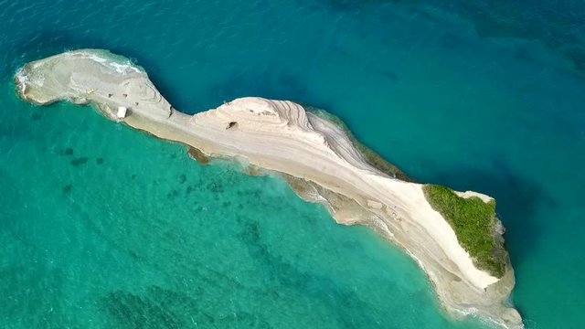 Aerial drone video of iconic white rock steep cliff volcanic bay of Cape Drastis and Peroulades area with tropical deep turquoise clear sea, Corfu island, Ionian, Greece