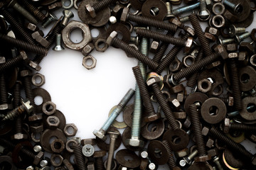 Assorted nuts and bolts shaped heart on white background.